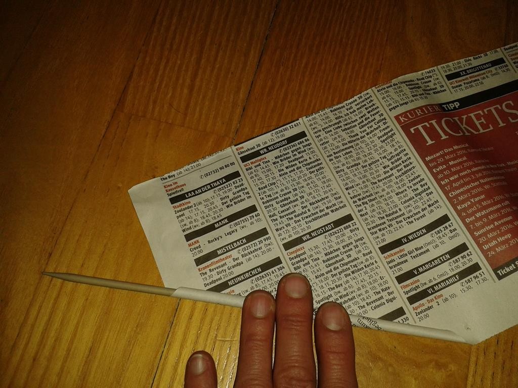 Aufrollen der Zeitung auf einer Stricknadel