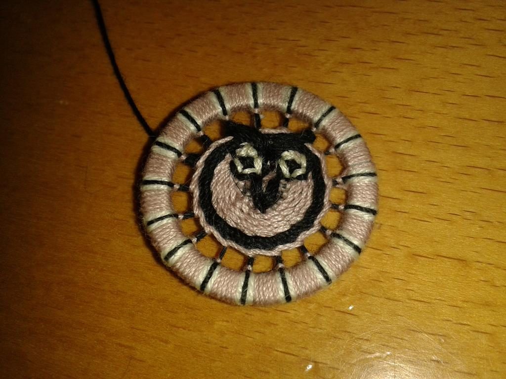 Zwirnknopf mit stilisiertem Eulenkopf